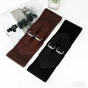 Detail of vintage wide elastic waist belts in brown and black with double metal buckles