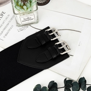 Detail of wide elastic waist belt with silver double buckles and faux leather texture