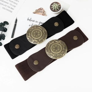 Detail of wide elastic belts featuring vintage gold floral buckles in black and brown