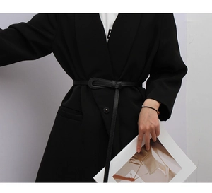Vue détaillée d'une ceinture fine noire nouée sur un blazer élégant pour femmes