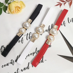 Detailed view of elastic waist belts in black, white and red with large double pearls
