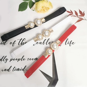 Detailed view of elastic waist belts in black, white, and red with double pearl buckles