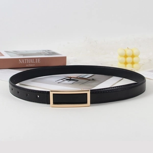 Detailed close-up of a slim black leather belt with golden buckle and fine stitching detail