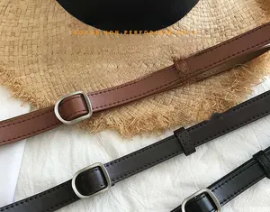 Detail of round non-perforated leather belts in black and brown with silver buckles