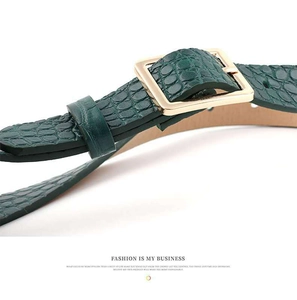 Close-up of dark green croc-pattern leather belt with a golden square metal buckle