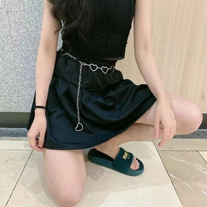 Silver heart-shaped metal waist chain for women with hollow links and pendant on black skirt