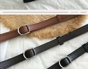 Close-up of minimalist slim belts in black and brown with silver matte buckles