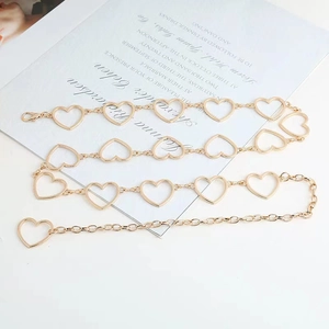 Detailed view of a golden heart chain belt with delicate hollow charms and lobster clasp