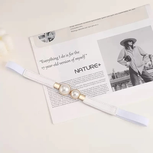 Close-up of white elastic waist belt featuring dual large pearls and gold metal buckle
