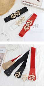 Detail of elastic waist belt with golden leaf buckle in multiple colors on white fabric