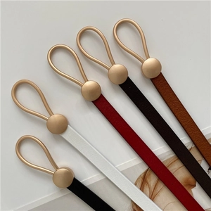 Flat lay of slim leather belts in five colors with matte gold buckles on a white background