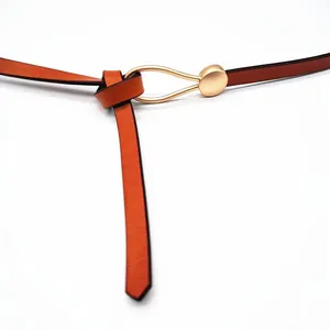 Detail of genuine leather skinny belt with elegant knot tie and gold round buckle