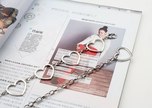 Detailed macro view of heart-shaped hollow metal chain links with a silver finish