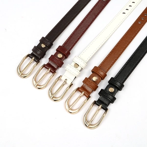 Flat lay of slim hollowed waist belts in five colors with gold oval pin buckles