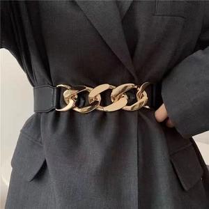 Ceinture corset élastique noire pour femme avec boucle chaîne dorée sur une veste
