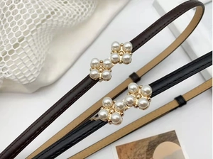Détail d'une boucle papillon en perles sur des ceintures fines en cuir pour robes