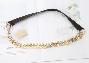 Close-up of gold chain and brown fabric strap with large lobster clasps for handbags