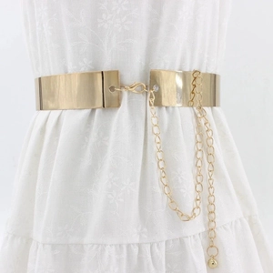 Polished gold mirror metal belt with elegant chain and pendant on white dress