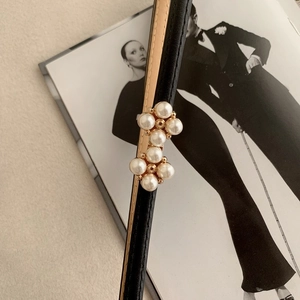 Ceinture fine en cuir noir avec boucle en perles élégante sur un magazine de mode