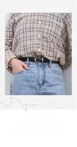 Gros plan d'une ceinture fine en cuir noir pour femme avec boucle dorée sur jean