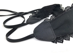 Close-up of black lace eye mask detail with silk fabric and faux leather reinforcement