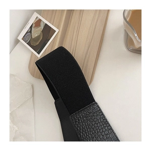 Large ceinture corset noire avec cuir motif crocodile sur un plateau décoratif
