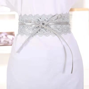Elegant silver lace-up obi belt with metallic finish on a white dress waist