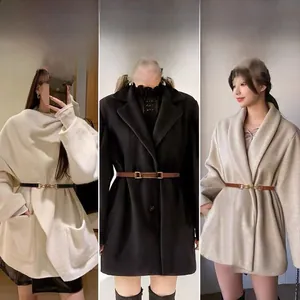 Close-up of slim waist belts with horsebit metal buckles on wool coats in black and brown
