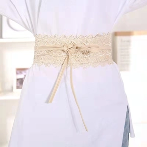 Detailed view of beige lace wide corset belt with drawstring closure on a dress