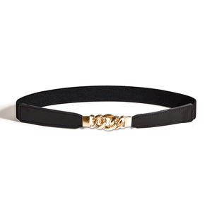 Détail d'une ceinture élastique noire avec boucle métallique à triple maillon doré