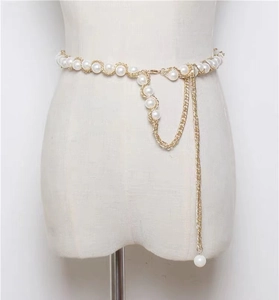 Détail de la chaîne de taille dorée pour femme avec perles blanches et pompons en cascade