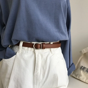 Classic brown leather belt with silver D-ring buckle on white trousers and blue shirt
