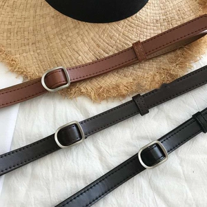 Detail view of retro slim leather belts in brown and black with matte silver buckles