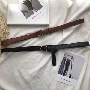 Flat lay of retro slim black and brown leather belts with silver square buckles