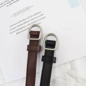 Detail of slim black and brown faux leather belts with silver D-ring metal buckles