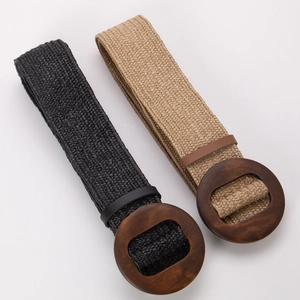 Detail view of woven straw belts in black and khaki with round vintage wooden buckles