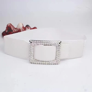 Close-up of white PU leather wide belt featuring a large sparkling rhinestone buckle