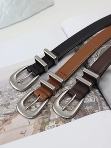 Close-up of vintage leather belts in black and brown with matte silver buckles