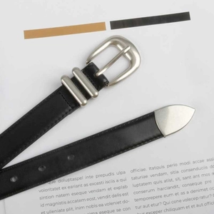 Close-up of black leather belt with silver D-ring buckle and metallic tip detail