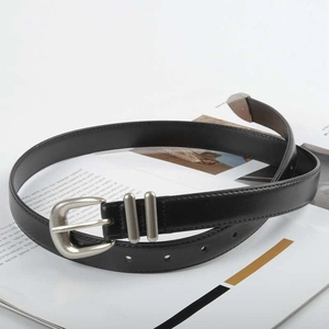 Detail of slim black leather belt with silver polished buckle and dual metal loops