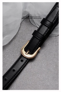 Vue détaillée d'une ceinture en cuir noir avec une élégante boucle dorée en fer à cheval