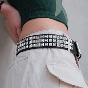 Détail d'une ceinture punk en cuir noir avec triple rangée de rivets carrés argentés