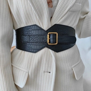 Women's wide black crocodile pattern elastic waist belt with large gold buckle on blazer