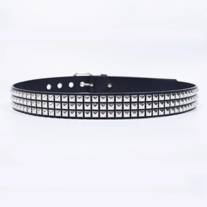 Détail d'une ceinture punk noire avec trois rangées de rivets carrés argentés et boucle à ardillon