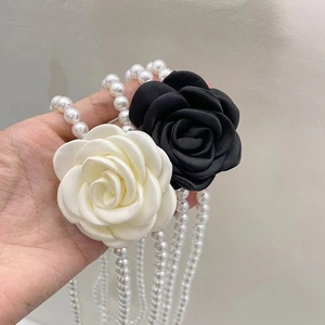 Detail of camellia flower belt featuring multi-strand white pearls and fabric blossoms