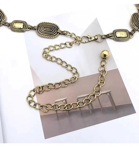 Detailed macro view of vintage gold engraved metal chain belt with ornate relief patterns