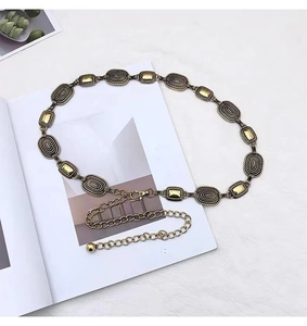Detail view of vintage silver metal chain belt with textured oval links and adjustable clasp