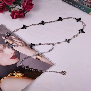 Detail of vintage silver waist chain featuring black butterfly charms and sparkling crystals