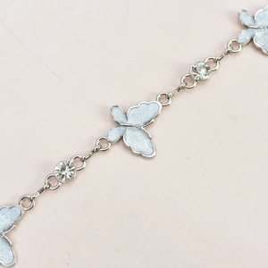 Detail of silver chain belt featuring butterfly pendants and clear sparkling crystals