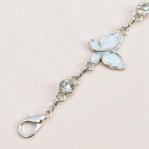 Macro detail of silver butterfly chain belt with crystal stones and lobster clasp closure